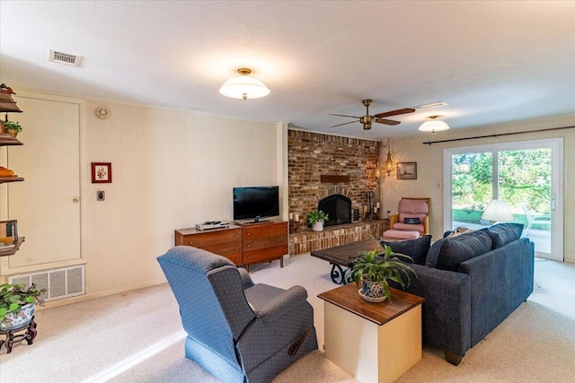 living room with visible vents, a fireplace, light carpet, and ceiling fan