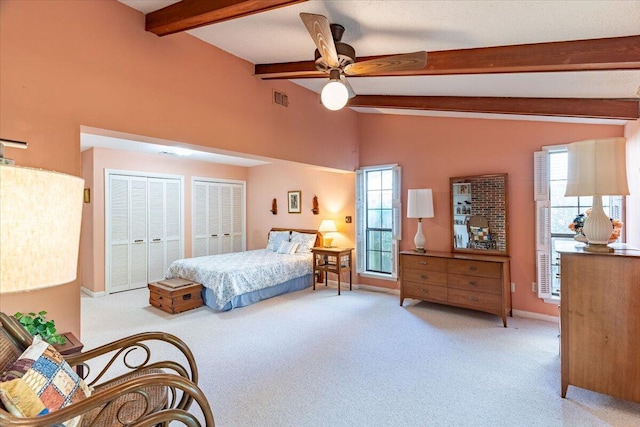 carpeted bedroom with multiple closets, visible vents, lofted ceiling with beams, and multiple windows