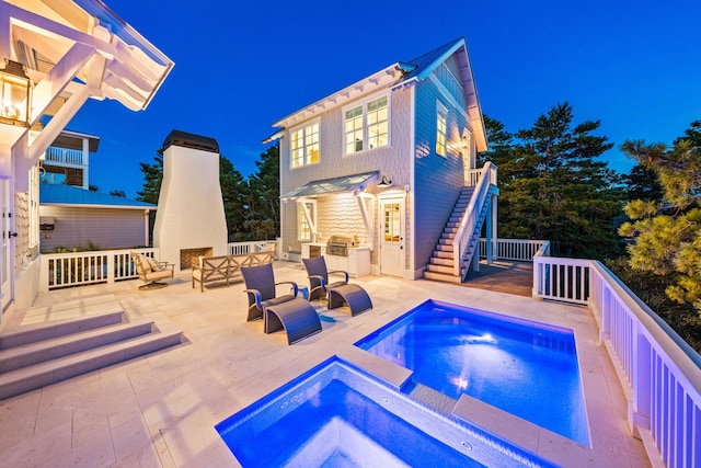 pool with a patio area, stairs, outdoor lounge area, and an in ground hot tub