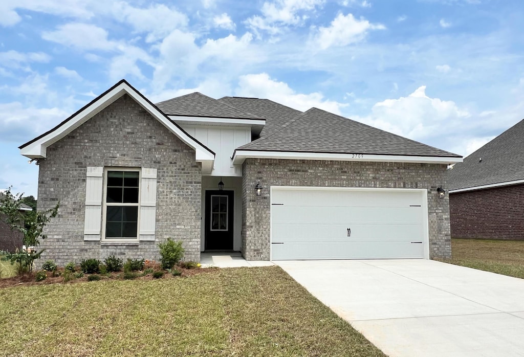 2709 Louis Cir, Crestview, FL 32536 - view of front facade featuring brick siding, a garage, a front yard, roof with shingles, and concrete driveway