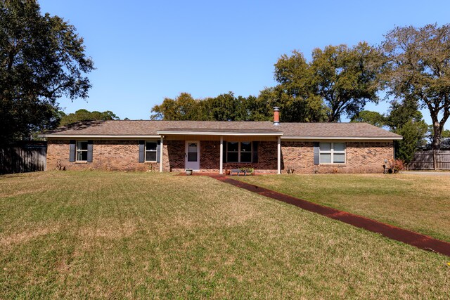 ranch-style home featuring fence, a front lawn, and brick siding