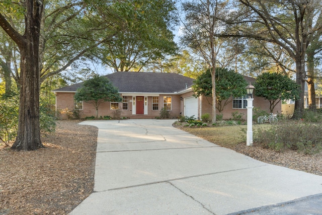 ranch-style home with concrete driveway and a garage