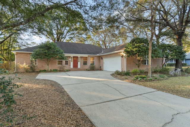 ranch-style home with concrete driveway, brick siding, and a garage