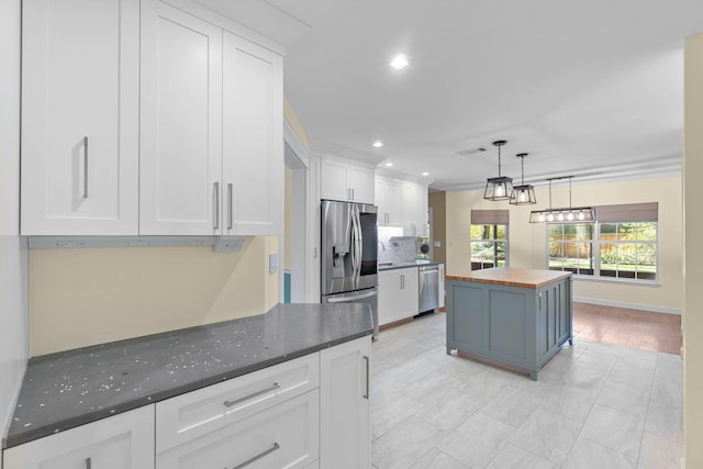 kitchen featuring wood counters, white cabinetry, recessed lighting, stainless steel appliances, and decorative backsplash