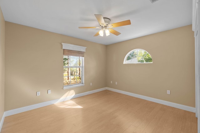 spare room featuring baseboards, light wood-style floors, and a healthy amount of sunlight