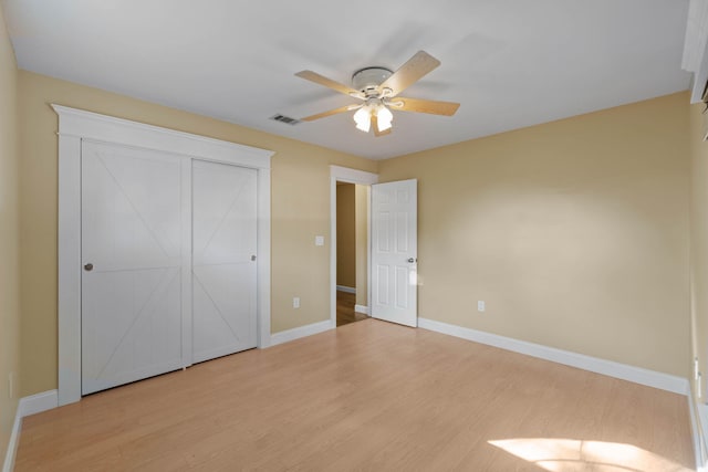 unfurnished bedroom featuring light wood finished floors, visible vents, ceiling fan, and baseboards