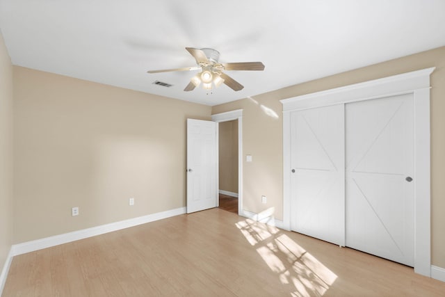 unfurnished bedroom featuring a ceiling fan, baseboards, visible vents, a closet, and light wood-type flooring