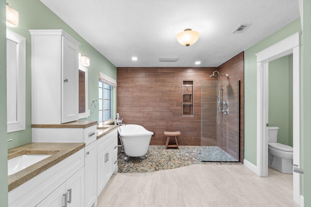 full bathroom with vanity, visible vents, a soaking tub, walk in shower, and toilet