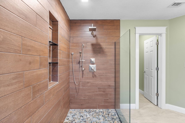 bathroom featuring visible vents, a walk in shower, and baseboards