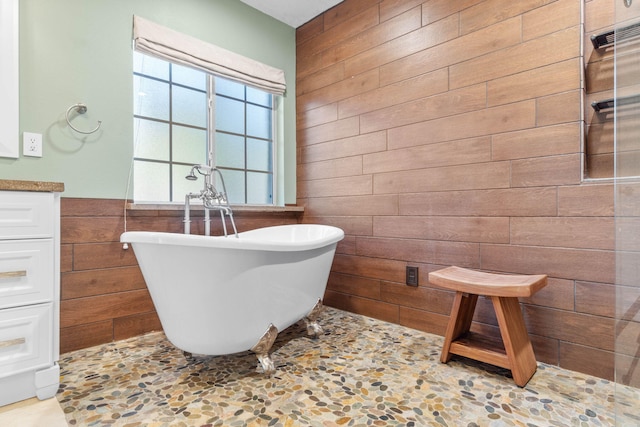 bathroom featuring a soaking tub and wooden walls