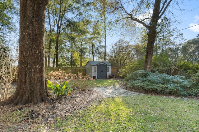 view of yard with an outbuilding, a storage shed, and fence