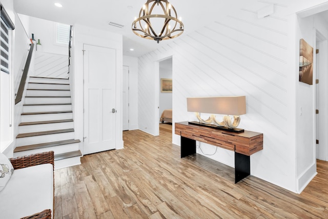 foyer with visible vents, light wood-style flooring, stairs, a chandelier, and recessed lighting