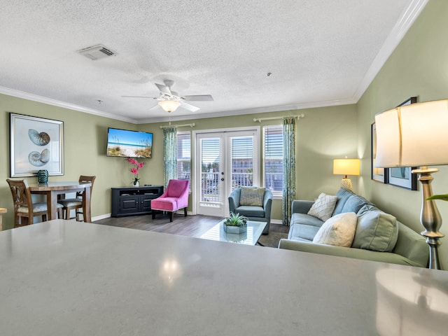 living room featuring french doors, visible vents, ornamental molding, wood finished floors, and baseboards