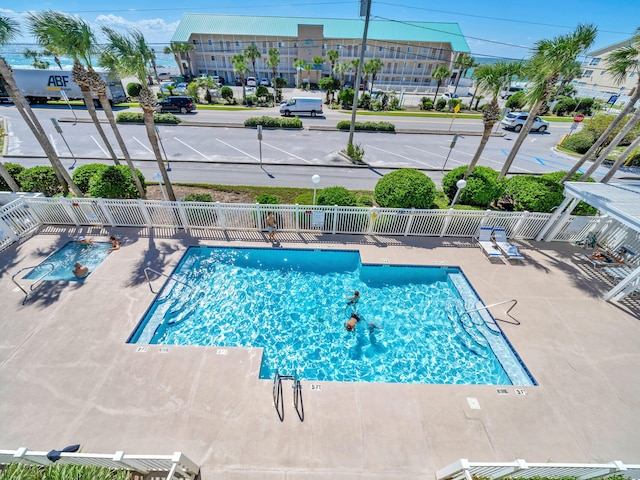 pool with a patio area and fence