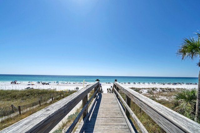 surrounding community with a beach view and a water view