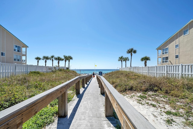 view of property's community featuring a water view and fence