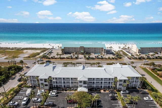 birds eye view of property with a water view and a beach view