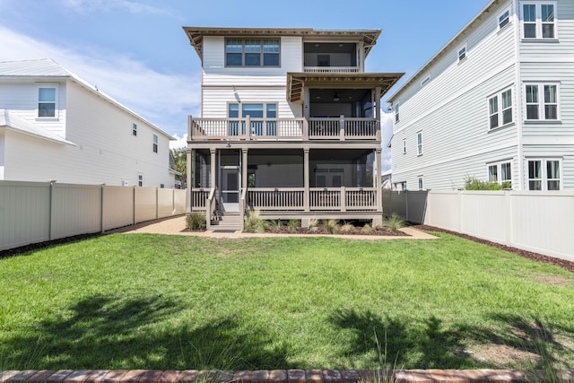 rear view of property featuring a balcony, a fenced backyard, a lawn, and a sunroom