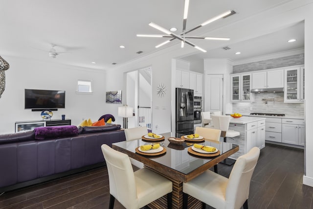 dining room with visible vents, dark wood finished floors, ornamental molding, recessed lighting, and ceiling fan with notable chandelier