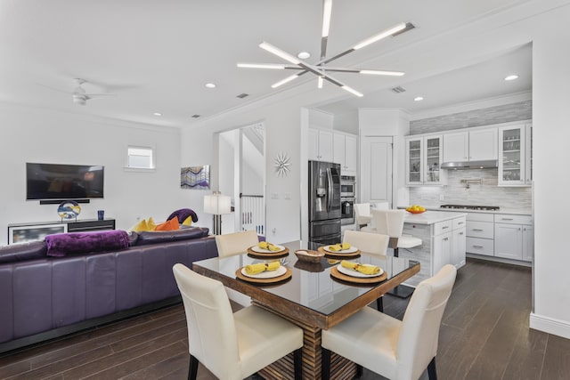 dining area featuring dark wood finished floors, recessed lighting, ceiling fan with notable chandelier, and ornamental molding