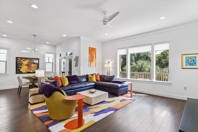 living area with a healthy amount of sunlight, dark wood-type flooring, crown molding, and a ceiling fan