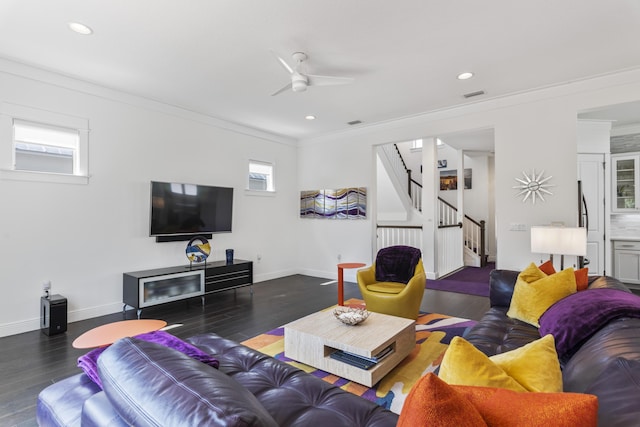 living area featuring stairway, wood finished floors, visible vents, and ornamental molding