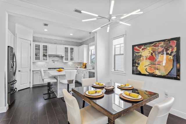 dining room with a notable chandelier, visible vents, ornamental molding, and dark wood-style flooring