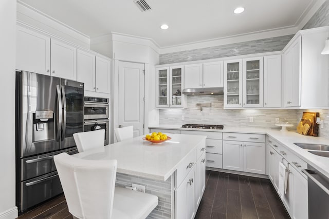 kitchen featuring visible vents, under cabinet range hood, dark wood finished floors, stainless steel appliances, and white cabinets