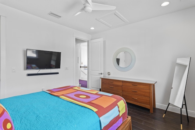 bedroom with a ceiling fan, visible vents, baseboards, dark wood finished floors, and attic access