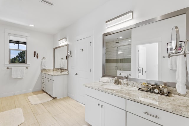 bathroom with a shower stall, two vanities, visible vents, and a sink