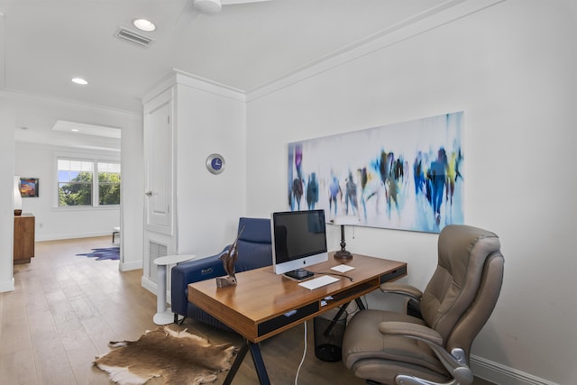 office space featuring light wood finished floors, visible vents, crown molding, and baseboards