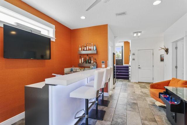 bar with visible vents, baseboards, wet bar, recessed lighting, and ceiling fan