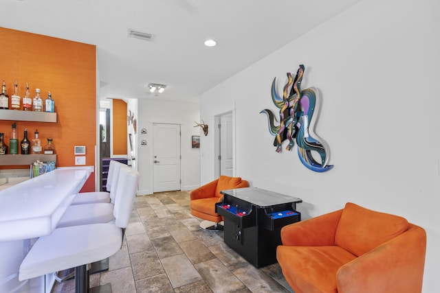 living room with visible vents and a bar