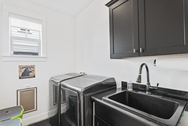 laundry area featuring cabinet space, washer and dryer, baseboards, and a sink