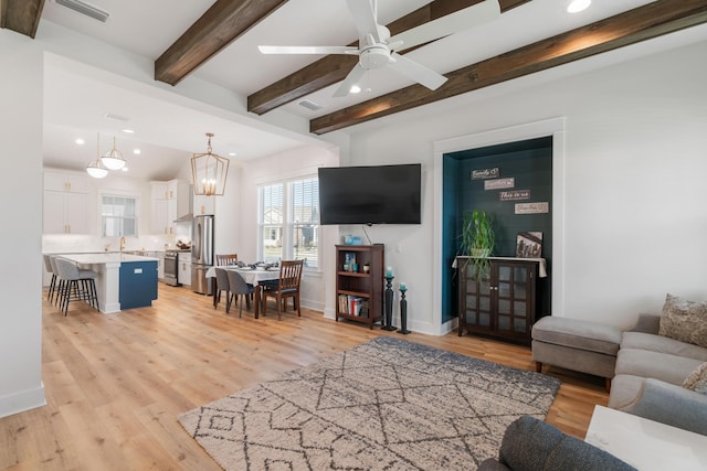 living area featuring beamed ceiling, recessed lighting, light wood-style floors, and visible vents