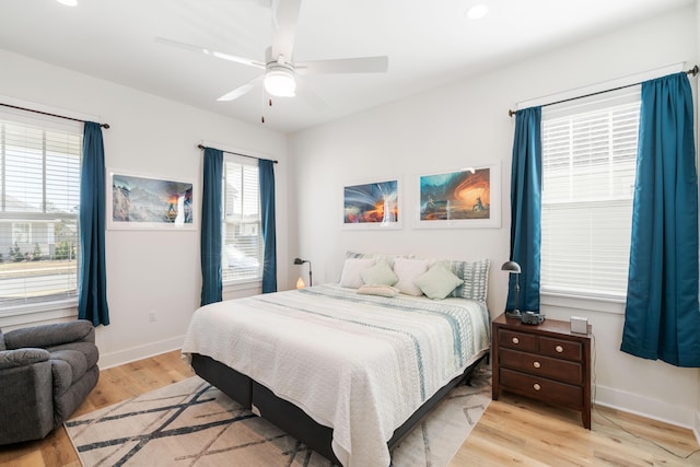 bedroom featuring light wood-style flooring, a ceiling fan, and baseboards