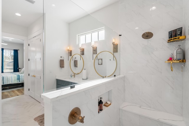 ensuite bathroom featuring recessed lighting, connected bathroom, tiled shower, and marble finish floor