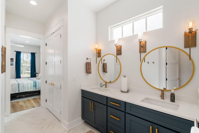 bathroom featuring double vanity, recessed lighting, marble finish floor, and a sink