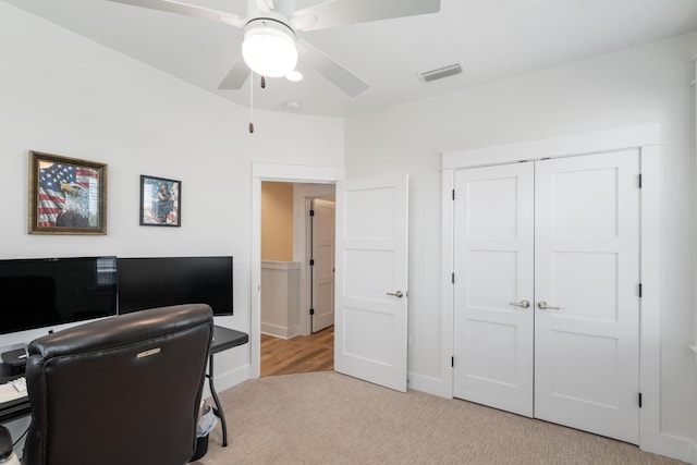 office area featuring visible vents, light carpet, and a ceiling fan