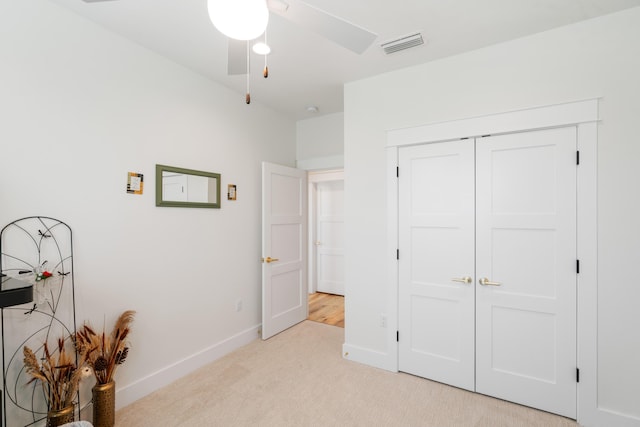 bedroom with light colored carpet, visible vents, a closet, and baseboards