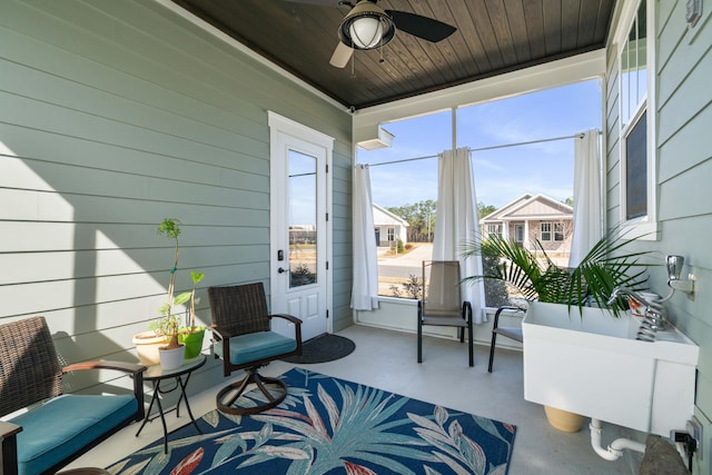 sunroom featuring a ceiling fan and wood ceiling