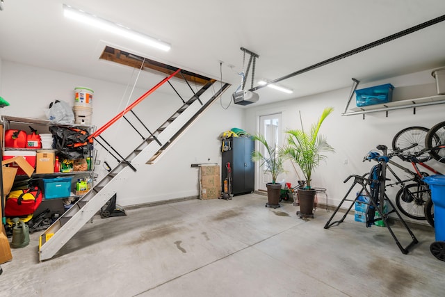 garage featuring a garage door opener and baseboards