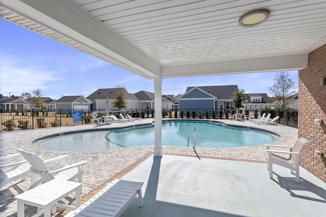 pool with a residential view, fence, and a patio area