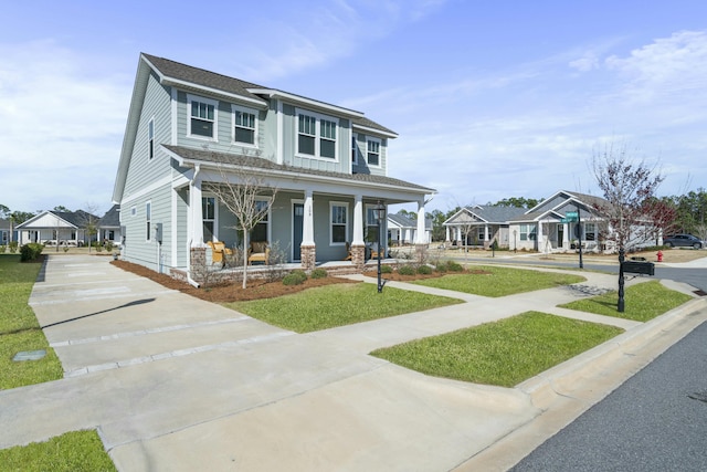 view of front of house featuring a porch, a front yard, and a shingled roof