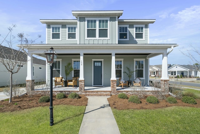 view of front of property featuring a front yard, covered porch, and board and batten siding