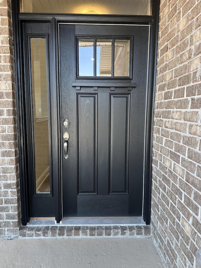 property entrance featuring brick siding