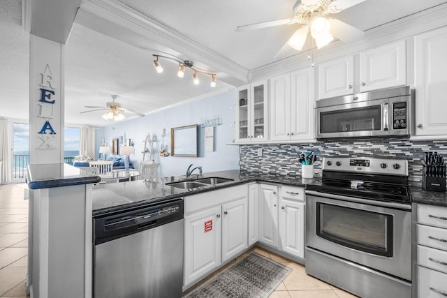 kitchen featuring stainless steel appliances, backsplash, light tile patterned flooring, a sink, and a peninsula