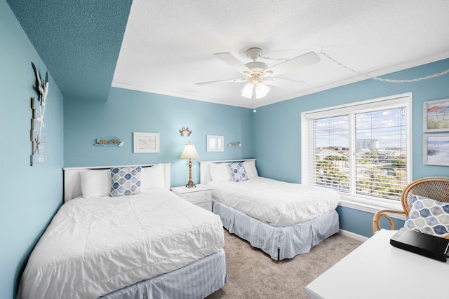 bedroom with a textured ceiling, carpet floors, ornamental molding, and ceiling fan