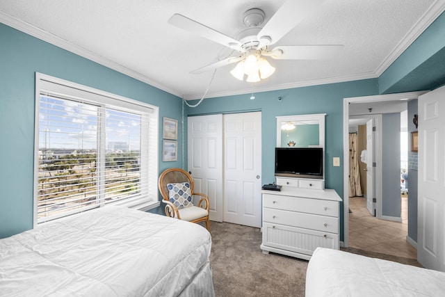 carpeted bedroom featuring crown molding, a textured ceiling, ceiling fan, and a closet