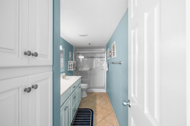 full bath featuring toilet, tile patterned floors, a textured ceiling, vanity, and a shower stall